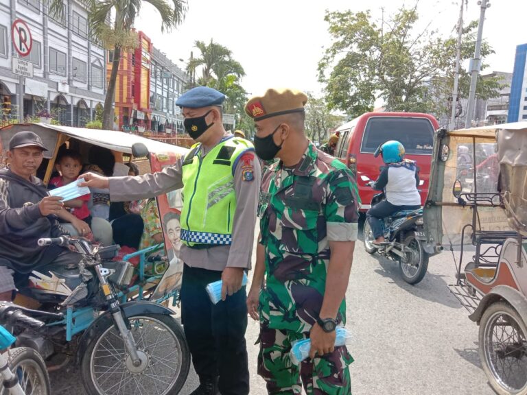 Gencarkan Yustisi, Brimob Polda Sumut Bagikan Masker di Simpang Limun
